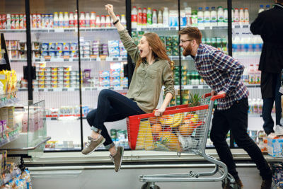 Man and woman having fun while shopping at the supermarket
