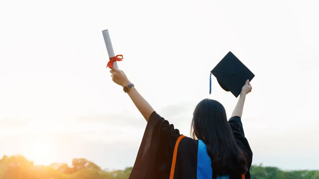 "Graduate raising diploma and cap